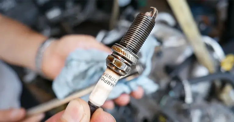 What causes and solutions a spark plug to foul?